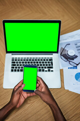 Fototapete - Green screen, laptop and hands on desk with phone, web design or online for marketing information. Technology, business person or digital with cellphone app for research, connect or typing by closeup