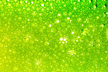 Wall Mural - Green macro bubble,Light Green Background Closeup of Oil Drops in Water. Abstract Macro Photo of Liquid Surface with Bubbles. Bright Design of Structural Watery Texture.