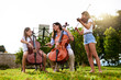 © peopleimages.com - Music, learning and children with violin and cello in park for playing, practice and lesson with teacher. Morning, nature and woman and kids with instruments for talent show, rehearsal or recital