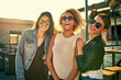 © peopleimages.com - Group of people, laughing and street style for fashion, together and bonding as friends in city. Women, happiness and sunglasses for outdoor, joy and summer with diversity, rooftop and fun on weekend