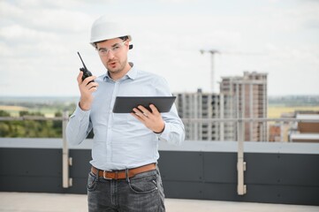 Construction concept. Portrait of a young architect at a construction site