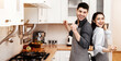 © Prostock-studio - Having Fun. Carefree beautiful european couple wearing aprons dancing in the kitchen, cooking delicious dinner