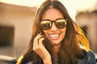 © peopleimages.com - Portrait, smile and sunglasses with woman outdoor in summer for holiday, travel and vacation. Face, shades and wellness with happy tourist person in urban neighborhood for break or trip abroad