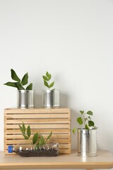 Wall Mural - Recycling concept. Metal cans and plastic bottle with plants on wooden table