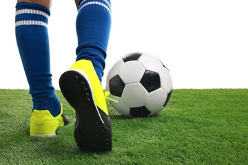 Wall Mural - Boy with soccer ball playing football on artificial grass against white background, closeup