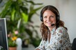 © Anton - Smiling woman with headset in front of computer
