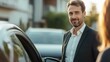 © pae - A well-dressed man stands beside a car, smiling warmly, as sunlight bathes the scene, creating a friendly and inviting atmosphere.