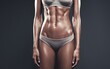 © BackgroundStudio - Close-up of a woman's toned abs in a sports bra and underwear.