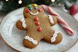 © Muhammad - Festive gingerbread man with colorful buttons and a candy cane, sitting on a snowy plate