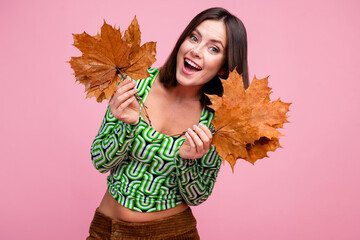 Photo of positive adorable woman wear green trendy clothes hold bouquet dry leaves isolated on pink color background