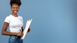 © hisilly - Joyful African American Woman with Clipboard on Blue Background
