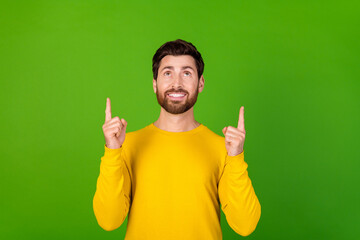 Poster - Photo portrait of attractive young man point look up empty space dressed stylish yellow clothes isolated on green color background