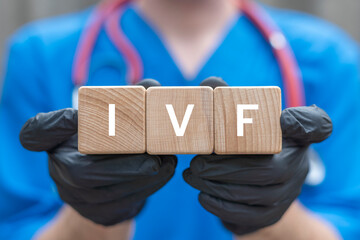 Doctor holding wooden cubes with abbreviation: IVF. IVF In Vitro Fertilization Concept. Infertility treatment. Medical procedure for pregnancy.