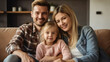 © halo - A happy family of three sitting on the sofa in their modern apartment.