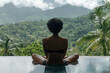 © Nalinthip - A woman is sitting in a pool, looking out at the mountains