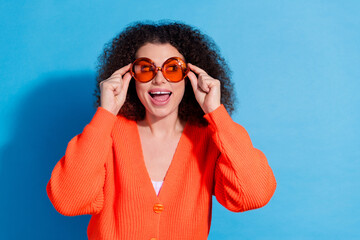 Canvas Print - Photo portrait of curly chevelure hair latin model woman tourist wearing trying new stylish sunglasses isolated on blue color background