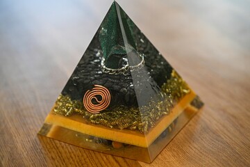 High resolution image of a single isolated beautiful one of a kind hand made Orgone pyramid generator containing crystals