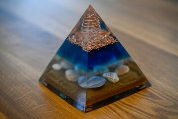 High resolution image of a single isolated beautiful one of a kind hand made Orgone pyramid generator containing crystals