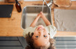 © peopleimages.com - Kid, portrait and water for washing in kitchen sink with learning healthy habits, hygiene routine and disinfection. Girl, top view and liquid soap for dirt, bacteria prevention and protection in home