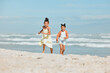 © peopleimages.com - Young girls, run and beach with fun, vacation and holiday together with game outdoor in the sun. Sea, youth and summer break with happy, smile and care of sibling with travel on trip in Miami