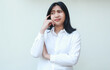 © M Alfan Setyawan - portrait of stress asian young woman manager thinking business plan strategy with hand touch face and arm folded dressed in white suit, standing with confusion