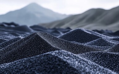 In the early morning hours, textured black sand dunes are under soft light near a coastal landscape