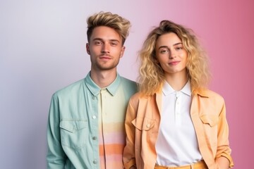 Canvas Print - A man and a woman are standing next to each other, both wearing orange