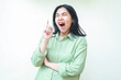 © M Alfan Setyawan - tired yawning asian woman pointing finger up to empty space and folding arms with eyes closed and mouth wide open just wakeup gesture wearing green oversiszed pajamas isolated on white