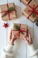 Wall Mural - Pack a gift for Christmas and new year in kraft paper, tied with a rope with a bow with Christmas decor on a white board table, natural decor. Festive mood. Flatlay, background, copy space