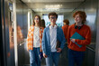 © Nomad_Soul - Three teenagers standing inside the elevator holding folder with papers