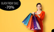 © vgstudio - Portrait of beautiful brunette woman wear orange dress standing isolated against yellow color background, holding showing shop bags with purchases. Black Friday holiday Sale, % sign - ad concept image