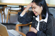 © M Alfan Setyawan - surprised asian woman sitting in cafe using laptop doing video call job interview touching her forehead