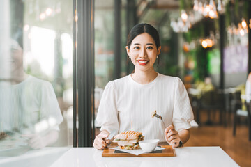 Asian woman healthy eating breakfast sandwich food diet meal at indoor cafe