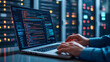 © Studios - Programmer or Computer Engineer working on a laptop with server room IT technology and database Concept of digital technology IT support telecommunications and IT security