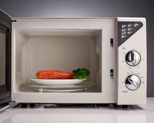 Salmon and broccoli on white plate in open microwave