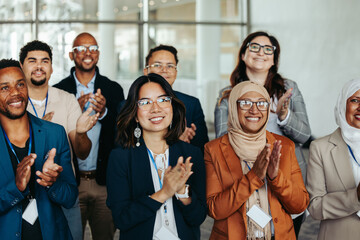 Wall Mural - diverse group of professionals applauding at a seminar, expressing happiness and engagement in a cor