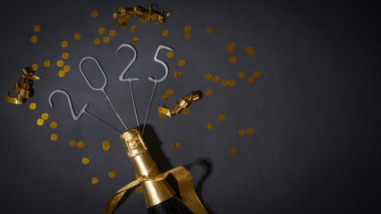 HAPPY NEW YEAR Silvester Sylvester New Year's eve greeting card - Gold champagne bottle and sparklers with year number 2025 and ribbons, isolated on black table background, top view