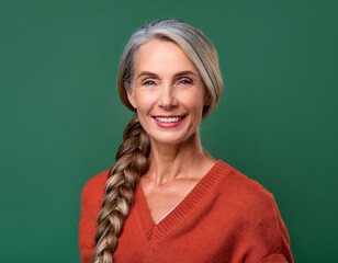 Wall Mural - Studio Portrait of Mature Teacher Woman Happily Smiling Against Colored Studio Background