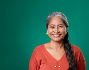 Wall Mural - Studio Portrait of Mature Teacher Woman Happily Smiling Against Colored Studio Background