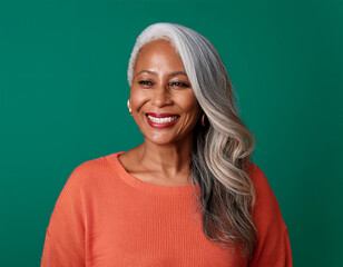 Wall Mural - Studio Portrait of Mature Teacher Woman Happily Smiling Against Colored Studio Background