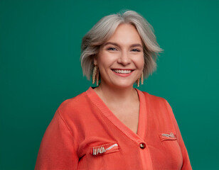 Wall Mural - Studio Portrait of Mature Teacher Woman Happily Smiling Against Colored Studio Background