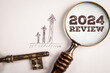 © STOATPHOTO - 2024 Review. Magnifying glass and key on white background