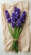 © Egor - A bunch of lavender flowers tied together with twine on brown paper.