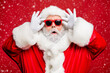 © deagreez - Close up photo of impressed funny santa claus have bad sight wonder incredible festive bargain wear stylish trendy white gloves isolated over red background