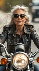 Wall Mural - A woman in a leather jacket and sunglasses is riding a motorcycle