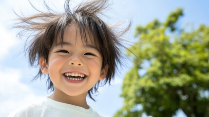 楽しい子供時代: 晴れた日に髪が乱れて笑っている子供 - 家族やライフスタイルのコンテンツに最適