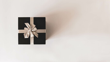 Black gift box from top view. Concept minimalist for wrapped Christmas and other holiday gifts. Gift decoration from top view with copy space