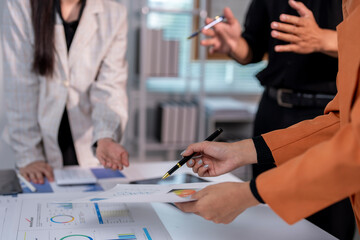 Wall Mural - Business people having meeting analyzing financial documents with charts graphs