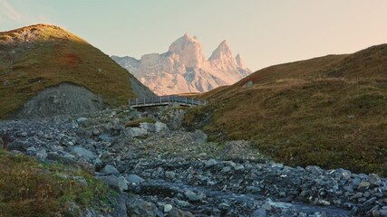 Wall Mural - Landscape of iconic three peak mountain and stream flowing in Aiguilles d Arves among French Alps