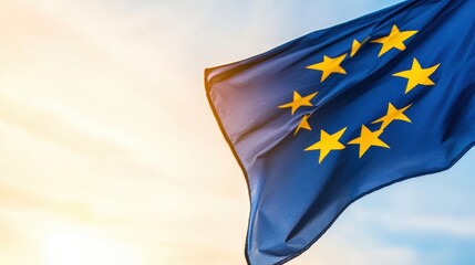 A close-up of the European Union flag waves gently in the breeze against a bright sky. Its blue background and twelve golden stars symbolize unity and strength among nations.